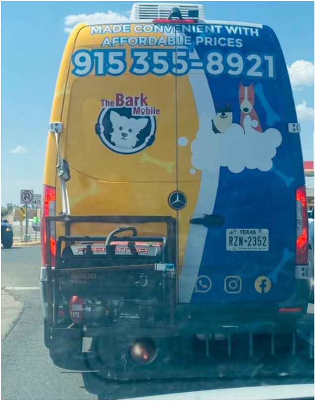 Rear of The Bark Mobile grooming van showing the logo and phone number 915 355-8921